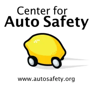 Logo of the Center for Auto Safety featuring a cartoon lemon-shaped car with wheels. The text 'Center for Auto Safety' is displayed prominently above, and the website URL 'www.autosafety.org' is shown below.